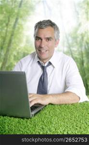 senior businessman working green grass desk computer forest jungle