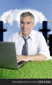 senior businessman working green grass desk computer smog indutrial smoke pollution