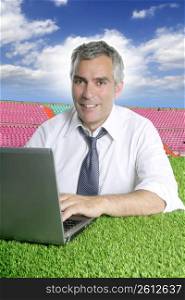 senior businessman working green grass in sport course