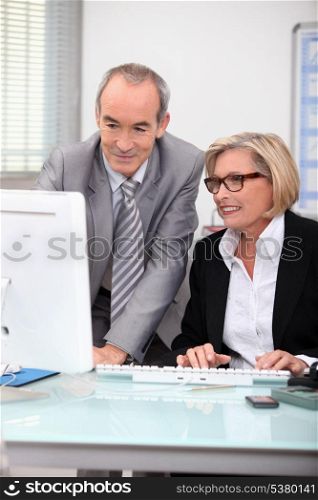 Senior businesspeople in front of laptop computer