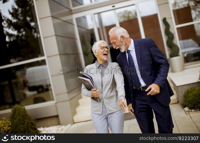 Senior businesspeople standing and talking outdoor office building