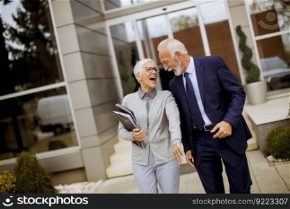 Senior businesspeople standing and talking outdoor office building