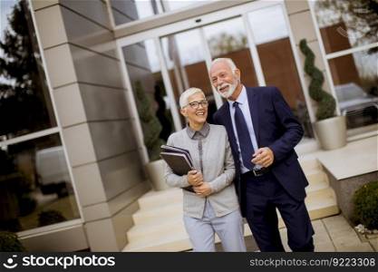 Senior businesspeople standing and talking outdoor office building