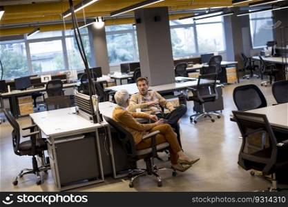 Senior businesswoman and young businessman having conversation in the modern office