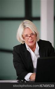 Senior businesswoman sending e-mails