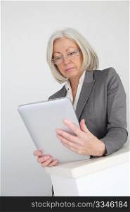 Senior businesswoman using electronic tablet in hall