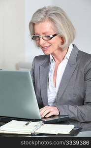 Senior businesswoman with eyeglasses working in the office