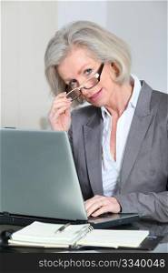 Senior businesswoman with eyeglasses working in the office