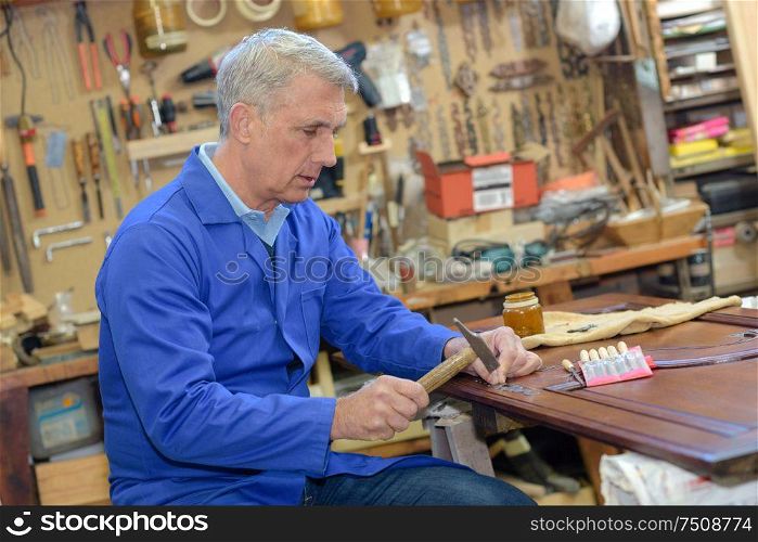 senior carpenter working in his workshop