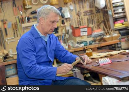 senior carpenter working in his workshop