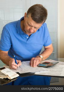 Senior caucasian man preparing tax form 1040 for tax year 2012 with receipts and calculator