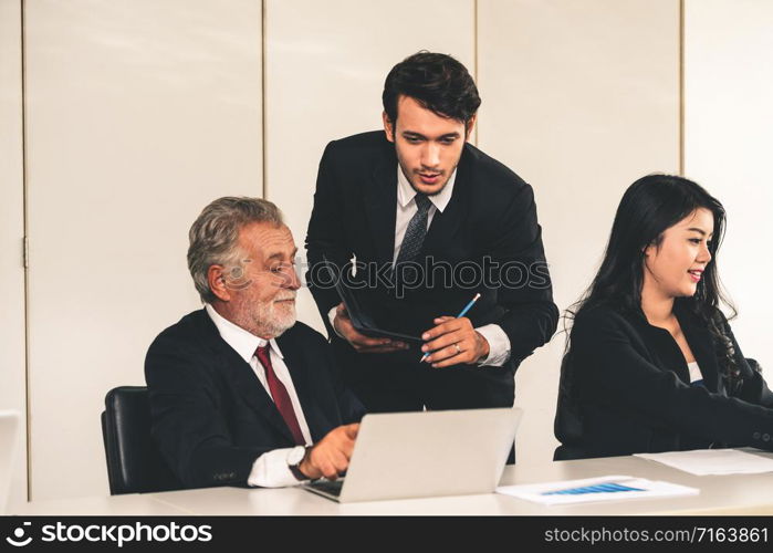 Senior caucasian manager working in office with assistance of young Asian business people and translator in the meeting. Corporate international business and secretary language translation concept.