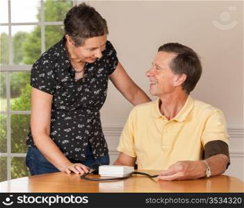 Senior caucasian retired male taking blood pressure at home