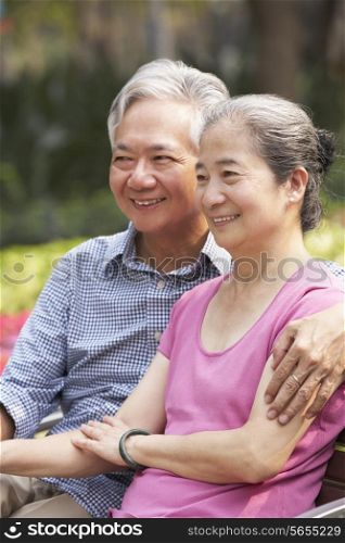 Senior Chinese Couple Relaxing On Park Bench Together