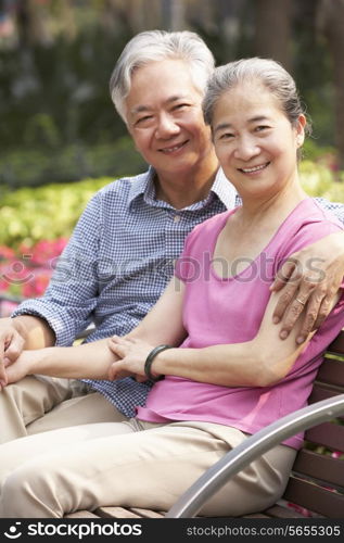 Senior Chinese Couple Relaxing On Park Bench Together