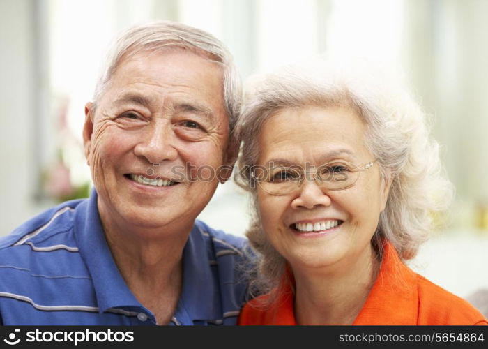 Senior Chinese Couple Relaxing On Sofa At Home