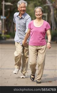 Senior Chinese Couple Walking In Park