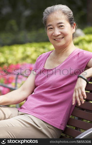 Senior Chinese Woman Relaxing On Park Bench