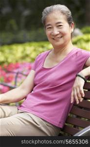Senior Chinese Woman Relaxing On Park Bench