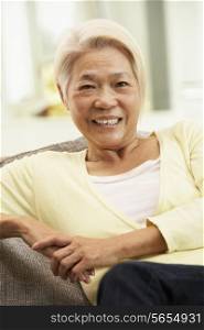 Senior Chinese Woman Relaxing On Sofa At Home