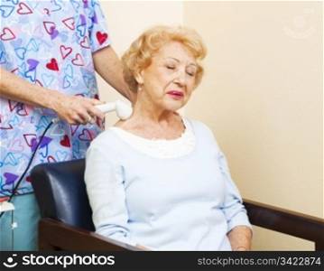 Senior chiropractic patient gets ultrasound therapy for her neck pain.