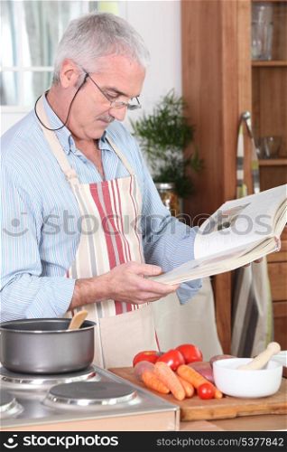 senior citizen cooking with recipe book