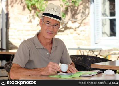 senior citizen sipping his coffee in terrace cafe