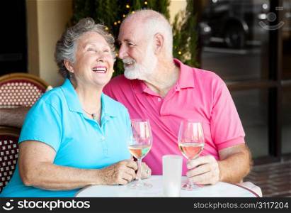 Senior couple at a cafe, enjoying wine and conversation together.