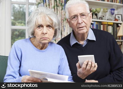 Senior Couple At Home With Bills Worried About Home Finances