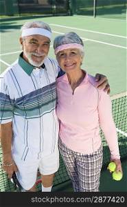 Senior couple at tennis court, portrait