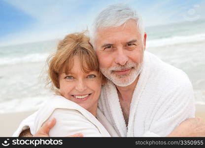 Senior couple at the beach with spa bathrobe