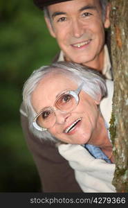 senior couple behind a tree