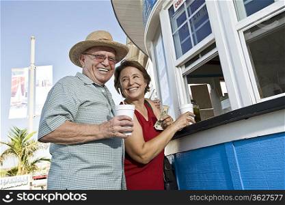 Senior couple buying drinks at food stand
