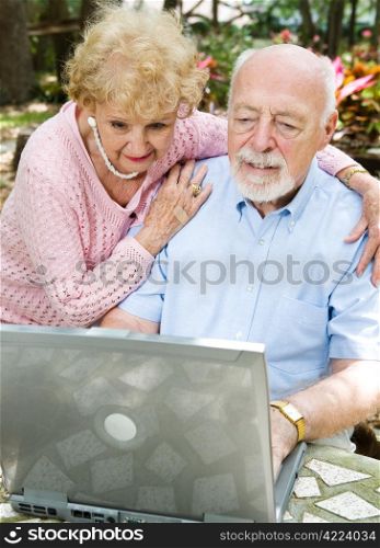 Senior couple checks their e-mail on the computer.