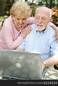 Senior couple checks their e-mail on the computer.