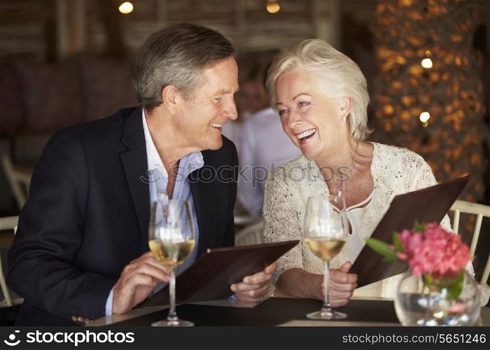 Senior Couple Choosing From Menu In Restaurant