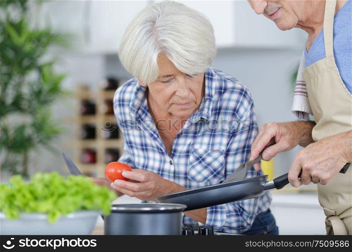 senior couple cooking fresh and healthy vegetarian meal