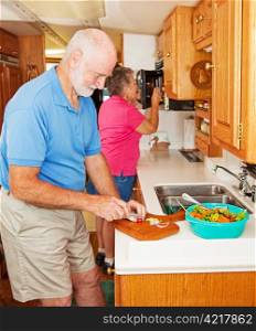 Senior couple cooking healthy dinner in the kitchen of their RV.