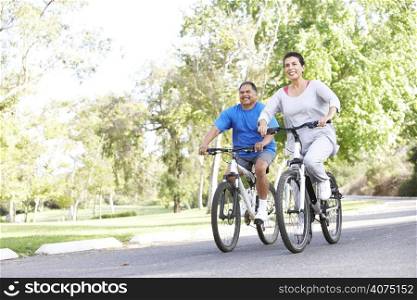 Senior Couple Cycling In Park