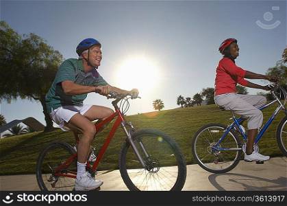 Senior couple cycling in park at dusk
