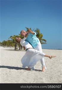 Senior couple dancing on tropical beach