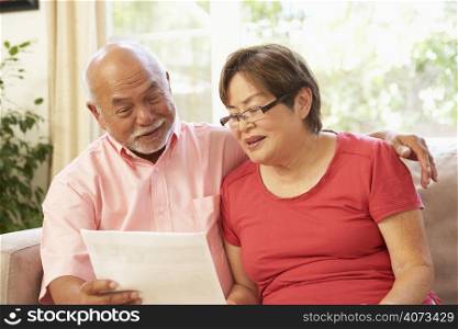 Senior Couple Discussing Document At Home
