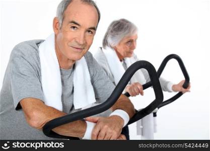 senior couple doing cardio machine