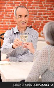 senior couple drinking champagne in a restaurant
