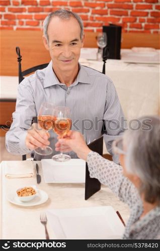 Senior couple drinking rose in a restaurant