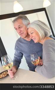 Senior couple drinking wine in home kitchen