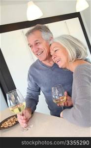 Senior couple drinking wine in home kitchen
