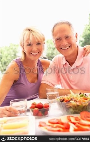 Senior couple eating outdoors