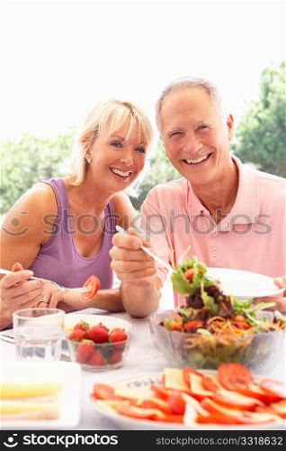 Senior couple eating outdoors