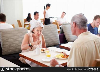 Senior Couple Enjoying Breakfast In Hotel Restaurant